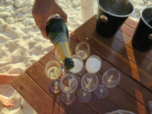 Pouring champagne on beach following the vow renewal cereemony
