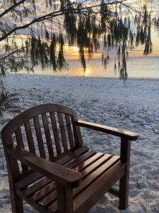 Chair on beach at sunset